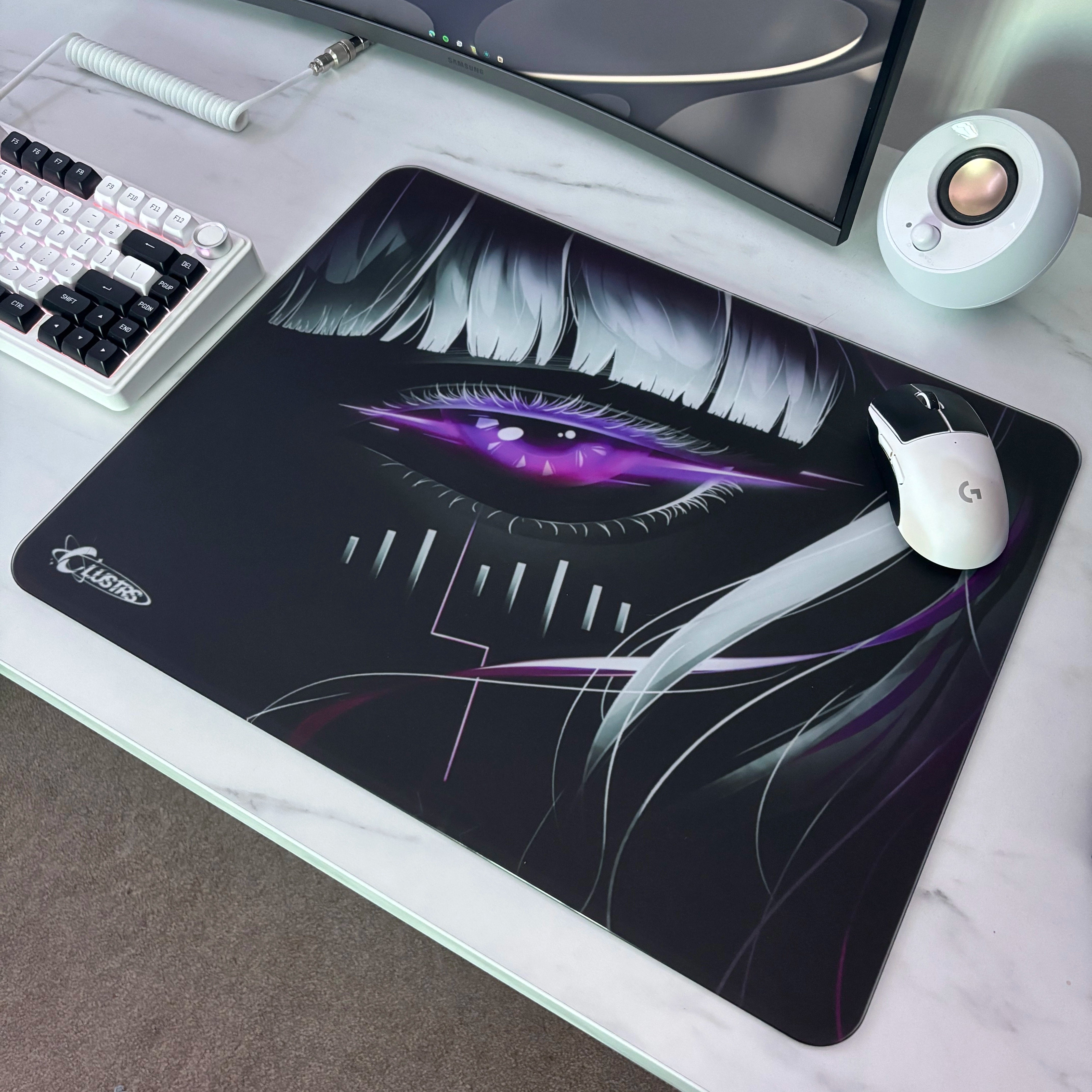 Aesthetic gaming desk setup featuring the Clustrs Astra’s Gaze Glass Pad Pro with a purple cyberpunk eye design, white wireless mouse, and mechanical keyboard on a marble surface.