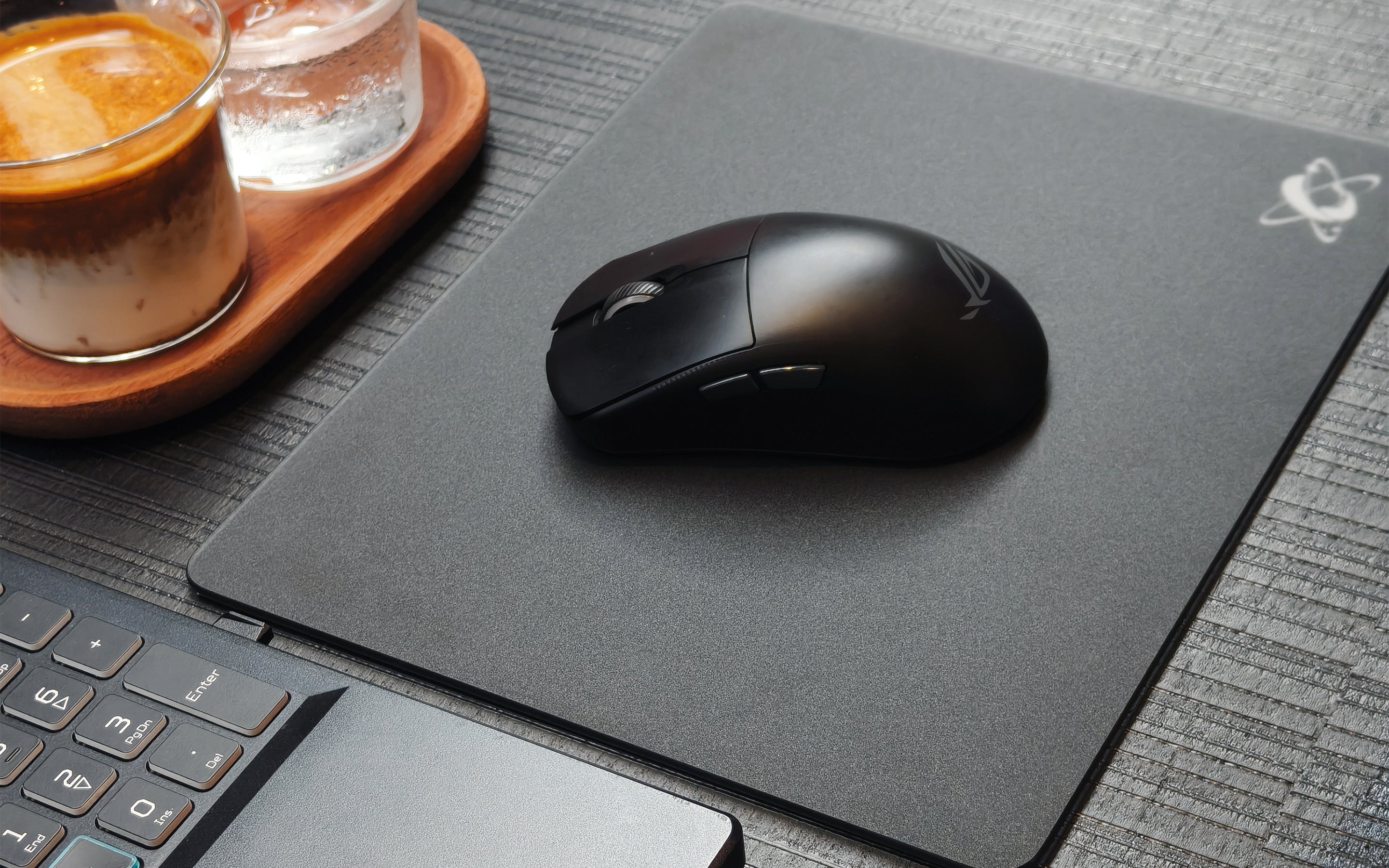A portable cafe desk setup with a glass mousepad, laptop stand, and mouse, creating a smooth and consistent glide for remote work productivity