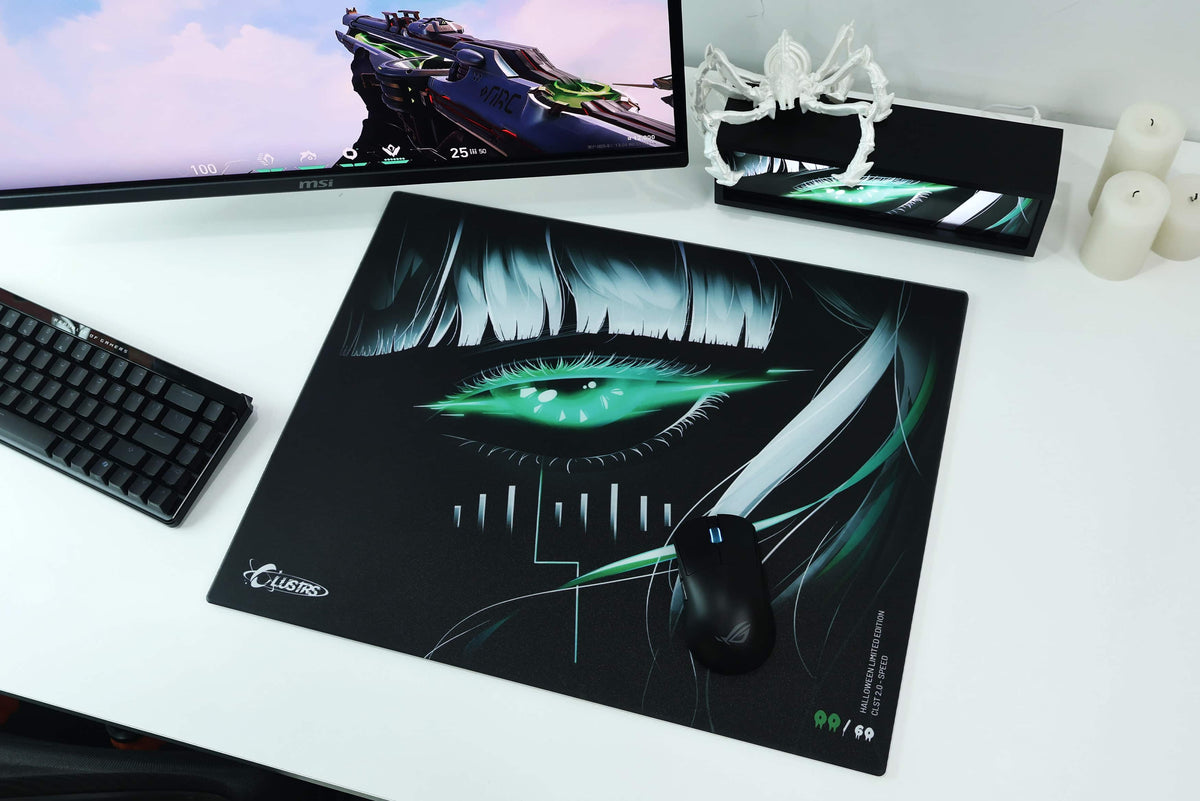 SPECTER Halloween glass mousepad with glowing green eye artwork on a white gaming desk setup with a keyboard, monitor, and mouse.