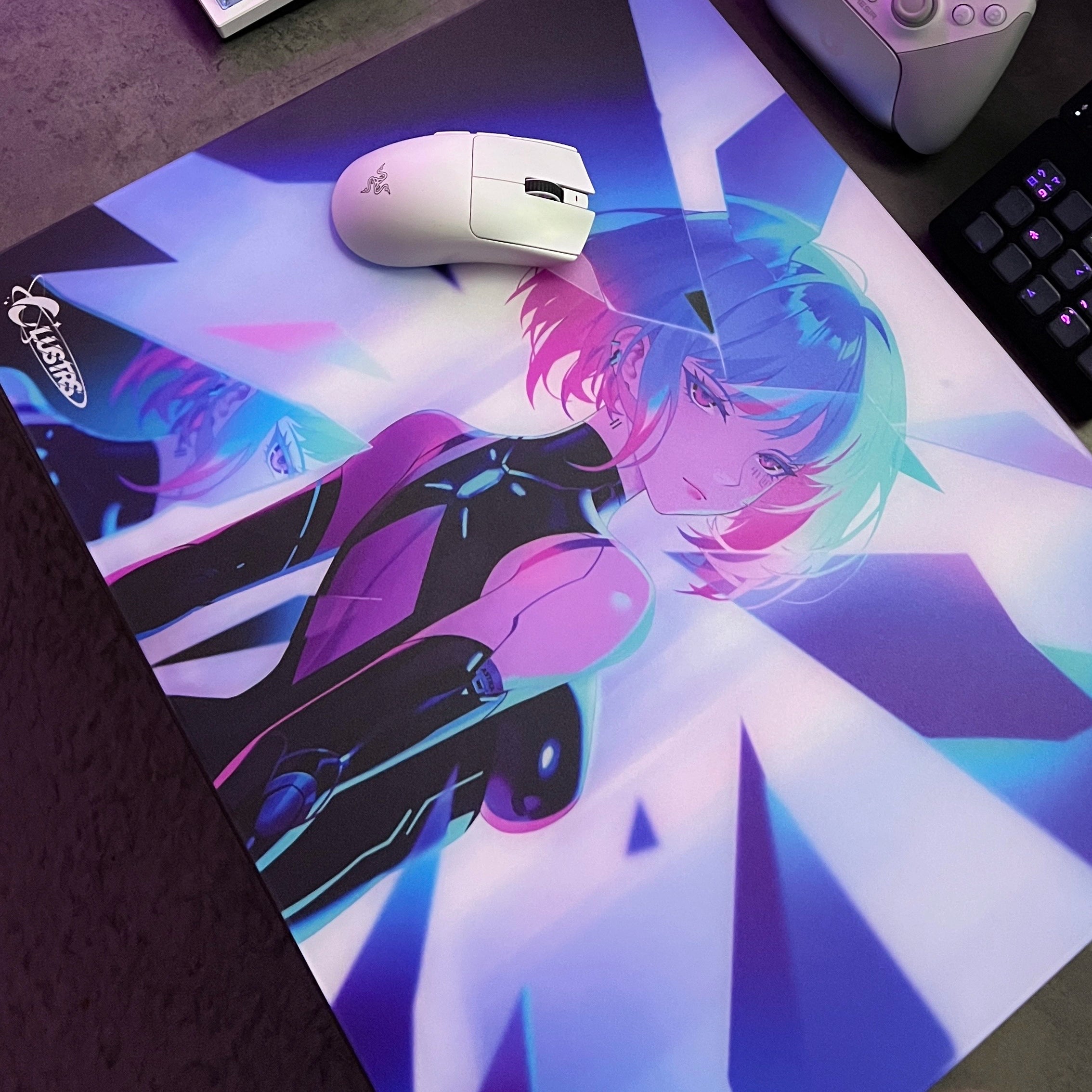 Close-up of the Clustrs Astra Glass Mouse Pad featuring vibrant neon anime artwork with blue and pink lighting, paired with a white gaming mouse on a dark desk setup.