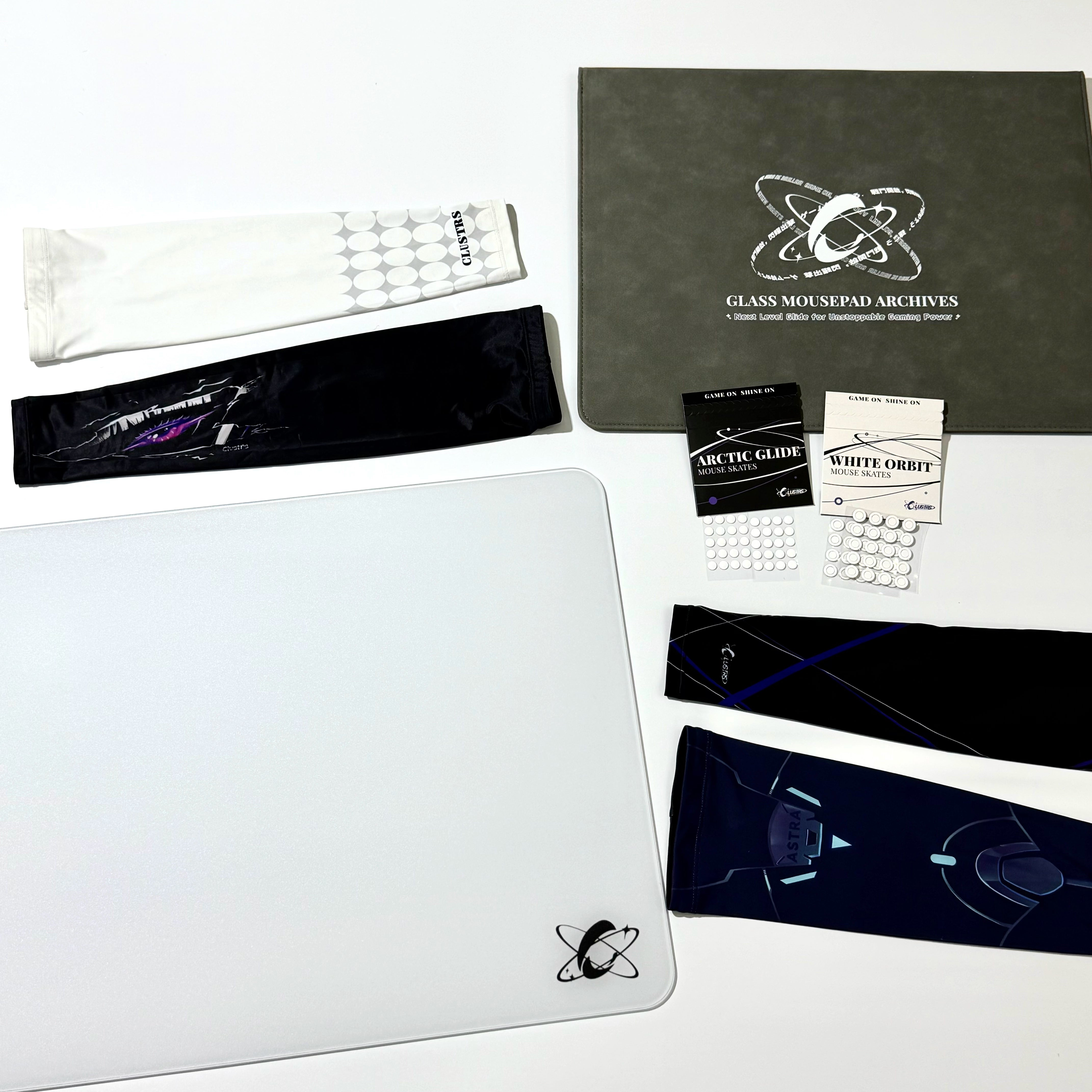 Clustrs Atom White Ultimate Bundle featuring the white glass mouse pad, multiple gaming sleeves, Arctic Glide and White Orbit mouse skates, and the premium storage case.