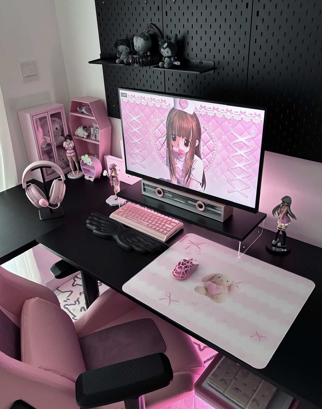Hug Me Bunny glass mousepad in a black and pink gaming setup with anime-inspired decor and a pink gaming chair.