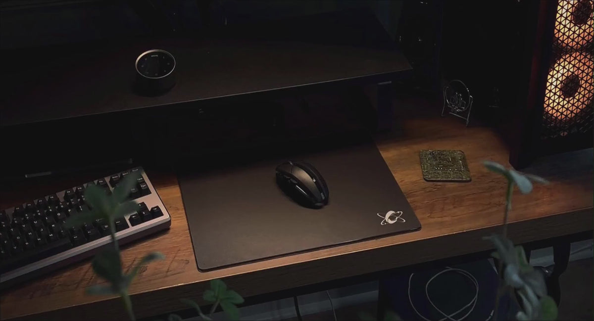 CLUSTRS ATOM black glass mousepad featured in a clean PC desk setup with a minimalist, performance-focused design.